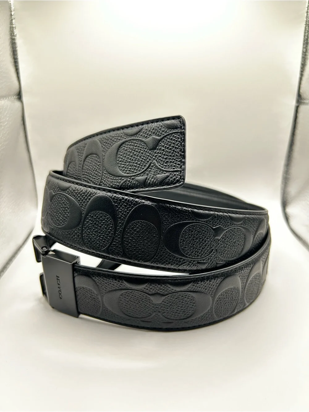 Black men’s coach belt with “c” pattern across the whole belt